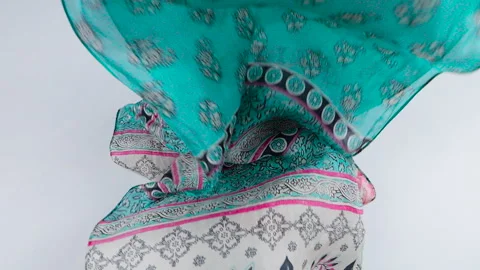 A beautiful silk fabric with a floral pattern falls smoothly in slow motion. Stock Footage 337402665