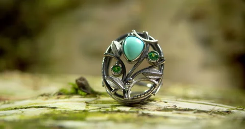 A beautiful silver ring with a turquoise stone rotates on a piece of tree bark. Stock Footage 165030774