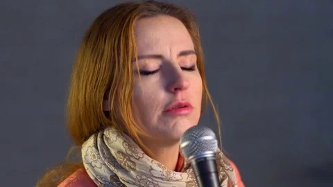 Beautiful singer singing into the microphone Stock-Footage 73687914