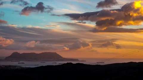 Beautiful sky with clouds floating by and tombolo in the background 스톡 동영상 77549113