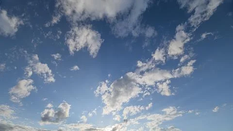 A Beautiful Sky Filled with Fluffy Clouds and Rays of Sunlight Bringing Warmth a Stockfoto's
