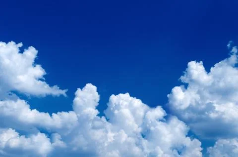 Beautiful sky half-blue, half with fluffy white clouds. Place for text. Stock Photos