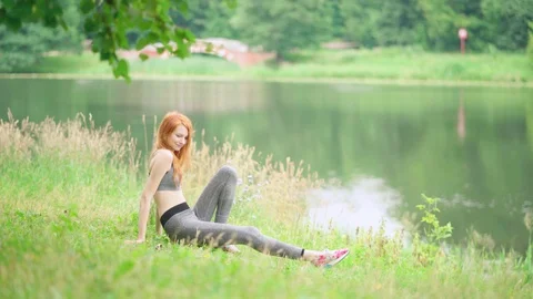 Beautiful slender woman practicing yoga in park. Stock Footage