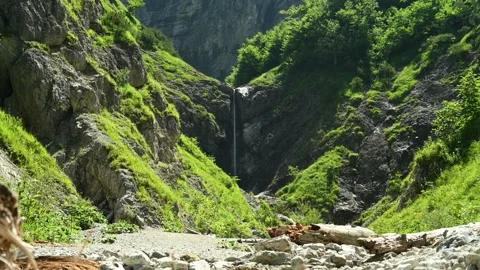 Beautiful slim waterfall in the end of a v shaped valley in the mountains Video stock 211500319
