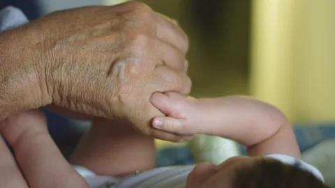 Beautiful slow motion of baby's hands holding grandfather's finger Stock Footage 114103717