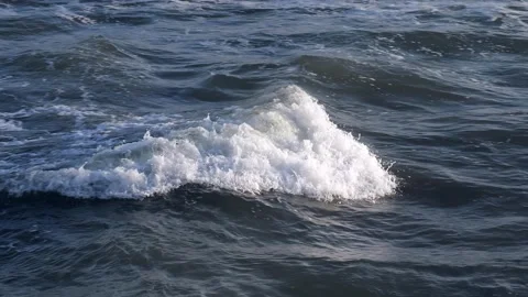 Beautiful slow motion of an ocean wave as it approaches the beach at sunset Stock Footage 134955940