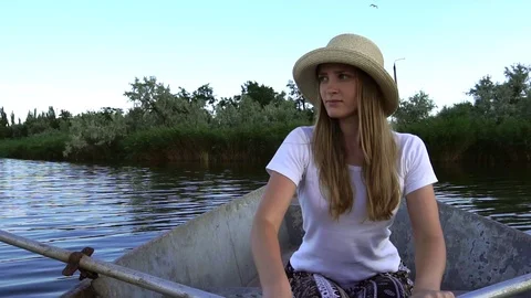 Beautiful slow motion view on tender young rower woman in straw hat sailing on Stock Footage 95048778