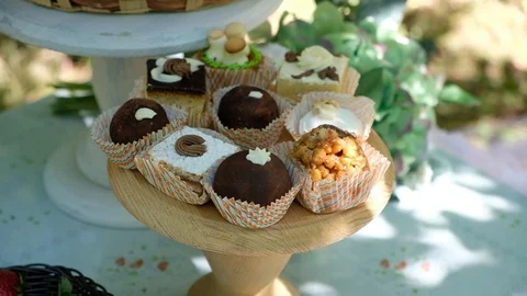 Beautiful small cakes at candy bar summer outdoors for birthday Видео 111767335