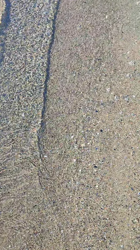 Beautiful small sea waves clean transparent water on sandy beach of sea shore Stock Footage 306071103