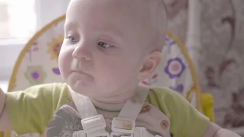 Beautiful small toddler boy at the table take a cookie in his hand, eating it Video stock 103983431