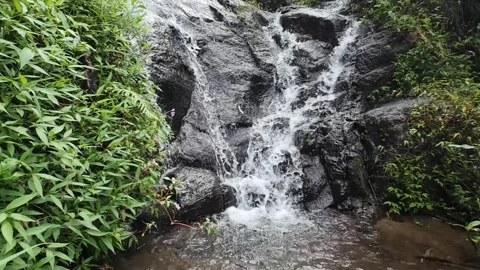 Beautiful Small Waterfall Flowing Through Dark Rock Stock Footage 336626860