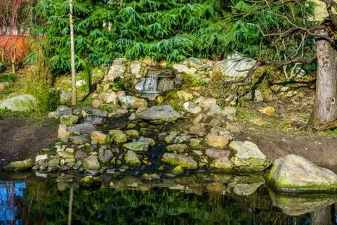 Beautiful small waterfall made of different stones, Natural garden decoration Stock Photos