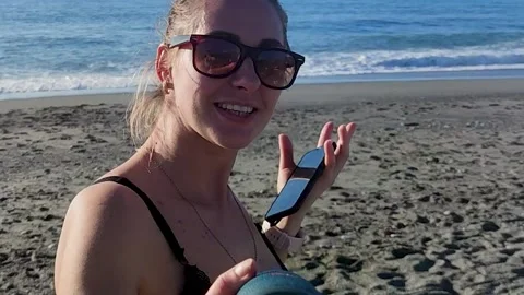 A Beautiful Smiling Blonde Dances and Sings While Spinning on the Beach. Stock Footage 228721983