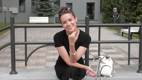 Beautiful smiling brunette model dressed in summer hipster black dress Stock Footage 141808285