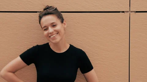 Beautiful smiling brunette model posing near yellow wall Video stock 141807592