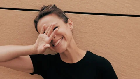 Beautiful smiling brunette model posing near yellow wall Stock Footage 141807642