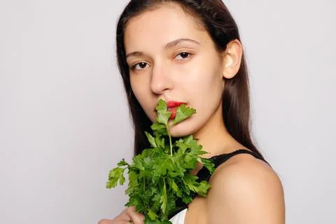 Beautiful smiling girl with parsley. Healthy lifestyle concept Stock Photos