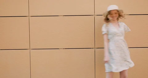 Beautiful smiling model posing near yellow wall in dress Stock Footage 142275383