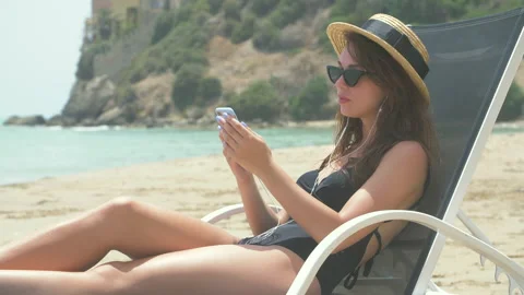 Beautiful Smiling Woman Lying on Deck Chair on Beach Stock Footage 140168053