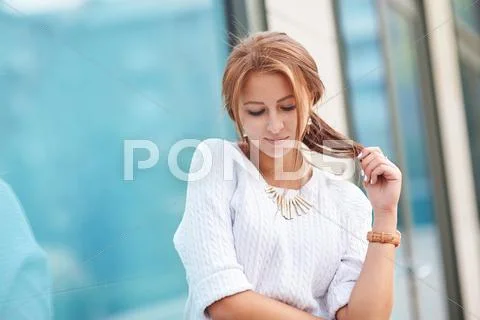 Beautiful smiling woman near the window on street Stock Photos