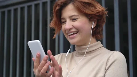 Beautiful smiling woman using mobile phone communication online on the street Stock-Footage 155374243
