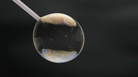 Beautiful soap bubbles are blown with a straw on a black background. Stock Footage 201993752