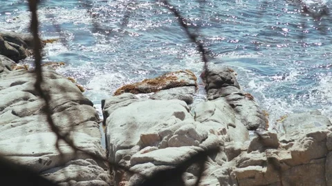Beautiful soft waves run over rocks and sand. Clear blue water with sun glare Stockbeeldmateriaal 154711006