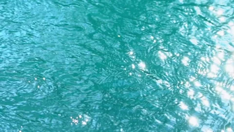 Beautiful sparkling shiny texture of blurry blue water with sun reflected on Stock Footage 132990908