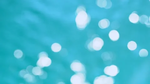 Beautiful sparkling shiny texture of blurry blue water with sun reflected on Video stock 134947749