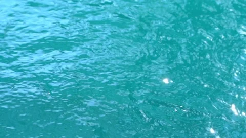 Beautiful sparkling shiny texture of blurry blue water with sun reflected on Stock Footage 135517663