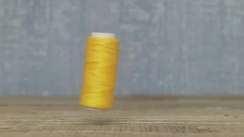 A beautiful spool of yellow thread is elegantly spinning on a lovely wellcrafted Видео 287454179