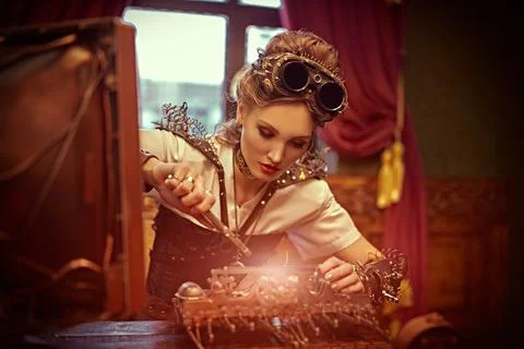 Beautiful steampunk lady scientist inventor repairs the mechanism in her labo Stock Photos