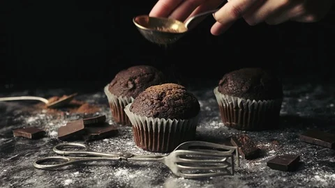 Beautiful still life footage of a hand sprinkling cinnamon on a muffin. Stock Footage