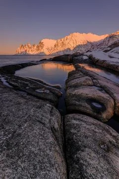 Beautiful stones and the reflection of the Devil Teeth mountains in a waterhole Stock Photos