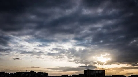 Beautiful storm clouds moving before the sunset in the city Stock Footage 75576397