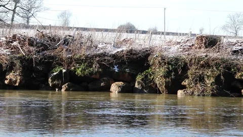 Beautiful stream of water flowing through a narrow snowy nature area Video stock 147192902