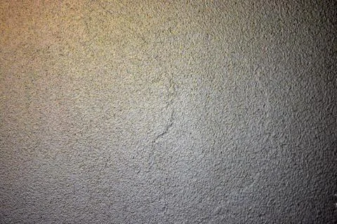 A beautiful structural light gray wall with golden highlights. Stock Photos