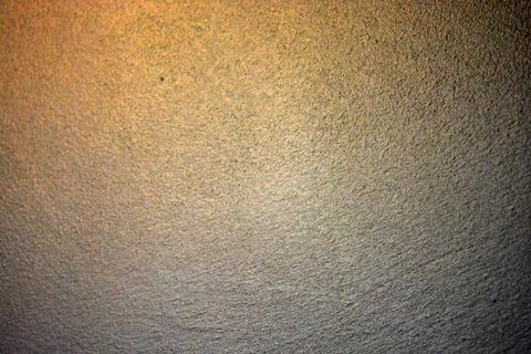 A beautiful structural light gray wall with golden highlights. Stock Photos