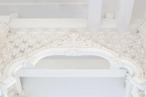 Beautiful stucco patterns on the wall of a white Buddhist temple. Architect.. Stock Photos
