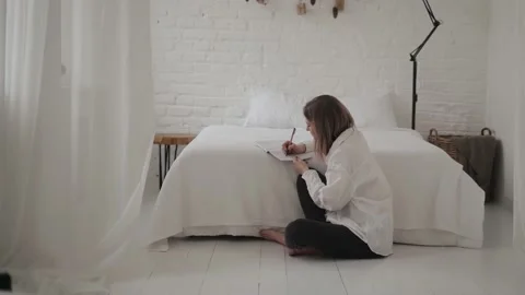Beautiful student girl making notes in paper notebook, writing creative idea Stock Footage 168747370
