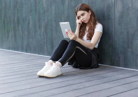 A beautiful student girl using a computer, laptop or Stock Photos