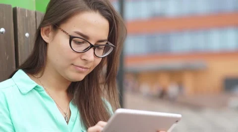 Beautiful student in glasses with a digital mini tablet Video stock 67170797