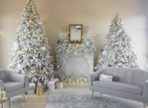 Beautiful stylish decorated interior two Christmas trees with a fireplace and Stock Photos