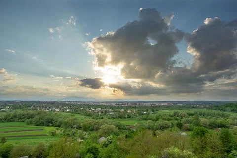 Beautiful summer landscape, sun rays at sunset over the city of Ivano-Frankiv Stock Photos