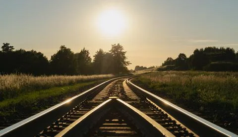 A beautiful summer sunset over the empty railroad tracks running through colo Stock Photos