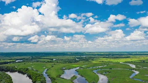 Beautiful summer time lapse over green meadows with river and clouds in the sky Stock Footage 254618733
