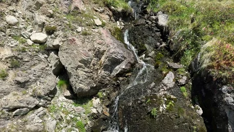 A Beautiful Summer Waterfall Flows Down a Rocky Mountainside in the Austria.. Stock Footage 343544457
