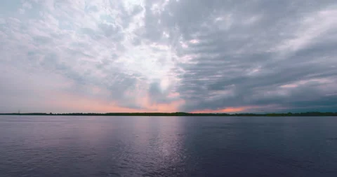 Beautiful sun rays in a colorful cloudy sky at the lake Stock Footage 130987599