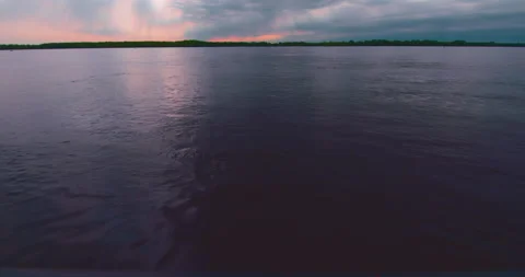 Beautiful sun rays in a colorful cloudy sky at the lake guardrail to the sky Stock Footage 130988246