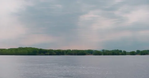 Beautiful sun rays in a colorful cloudy sky at the lake Видео 130989096